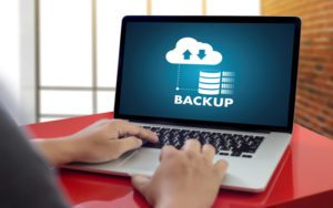 Person using laptop with Backup on the screen