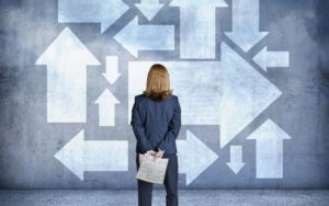 Business Woman standing in front of arrows