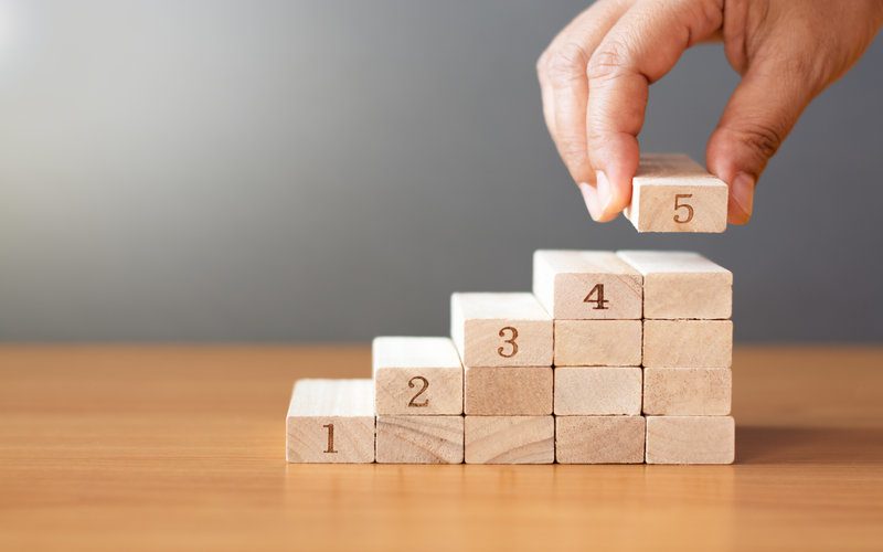 Person stacking numbered blocks