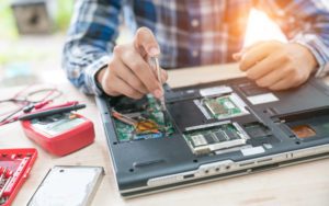 person fixing a broken laptop